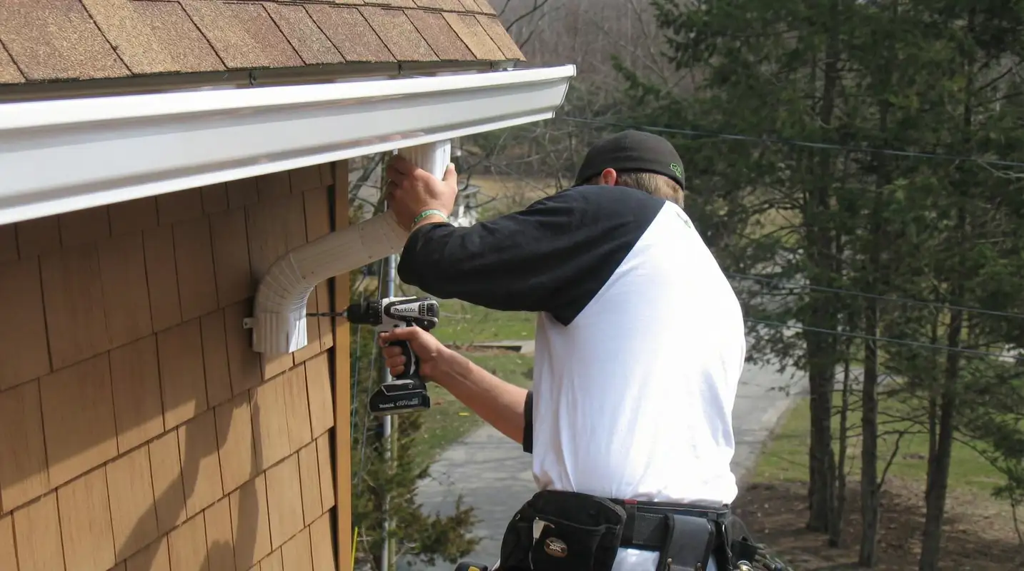 Professional contractor installing tan vinyl siding panels on a residential home exterior in Tacoma, WA